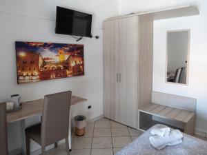 a room with a desk and a tv on the wall at Albachiara Suite Rooms in Bologna
