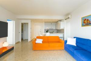ソットマリーナにあるLe Murrine Frontemare Apartment Seaviewのリビングルーム(オレンジ色のソファ、青色のソファ付)