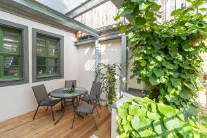 un patio con mesa, sillas y una planta en Altstadtbleibe, en Naumburg