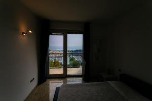 ソットマリーナにあるLe Murrine Frontemare Apartment Seaviewのベッド1台、景色を望む窓が備わる客室です。