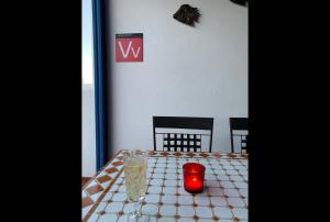 een tafel met een rode kaars op een witte tafeldoek bij Casa Sol Azul in Puerto Calero