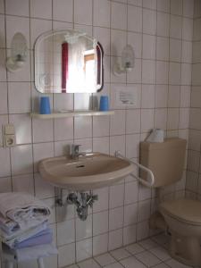 a bathroom with a sink and a toilet at Gasthof zum Kirchenwirt in Kirchdorf am Inn +17 photos
