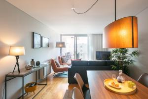 uma sala de estar com um sofá e uma mesa em Porto Insight Apartment Cedofeita- Balcony & Parking no Porto