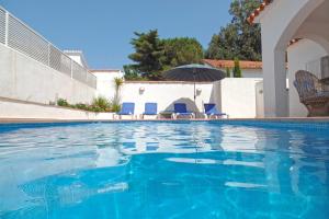 een zwembad met stoelen en een parasol bij Villa Riells Mar in L'Escala