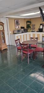 a dining room with a table and chairs and a clock at Conway Express Inn in Conway