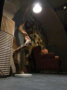 um quarto com uma cadeira e um galho de árvore no chão em La Stratodda Dimora Loft Mare Bandiera Blu 2023 em San Vito dei Normanni