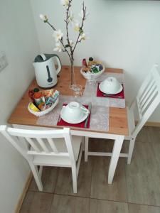 a white table with two chairs and a table with food on it at Casa Maria in Cantù