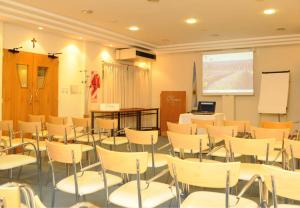 a classroom with white chairs and a white board at Parra Hotel & Suites in Rafaela