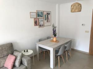 ein Wohnzimmer mit Tisch und Couch in der Unterkunft Apartamentos Trebol in Sanxenxo