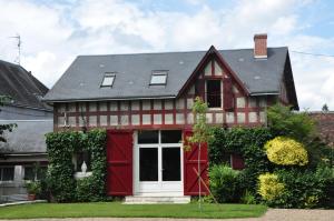 a red and white house with a white door at Le Clos du Petit Dannezy in Cour-Cheverny