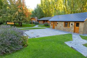 a home with a yard with a stone house at Santa Monica Aparts in El Calafate