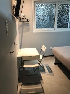 Un escritorio y una silla en una habitación con ventana. en athens.apartotel.box, en Atenas 1 foto más