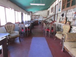 uma sala de jantar com mesas, cadeiras e janelas em Hostería Baños Morales em Santiago