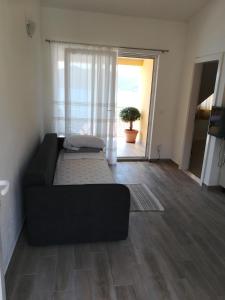 Apartmani Nedjeljka في فيغاني: أريكة سوداء في غرفة معيشة مع مدخل