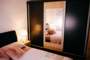 a bedroom with a mirror and a bed in it at Lux Apartment I Prijedor in Prijedor