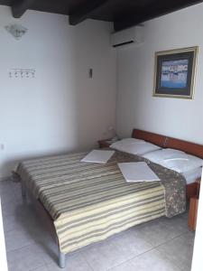 a bedroom with two beds with papers on top of it at Apartman Grospic in Cesarica