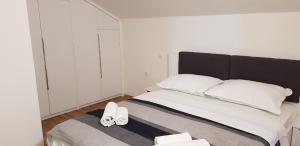 Un dormitorio con una cama con dos zapatos blancos. en Pansion Bojic, en Međugorje