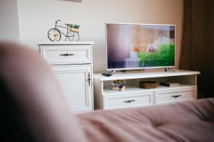 a tv sitting on a white stand in a bedroom at Lux Apartment I Prijedor in Prijedor