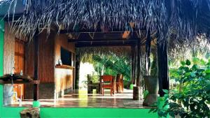 德雷克的住宿－Encanto Lodge，一间带桌子和稻草屋顶的用餐室