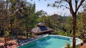 a swimming pool with a gazebo next to a tree at Lakeview Lodge Ngapali in Ngapali