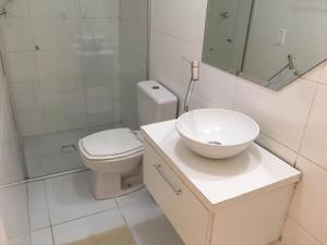 a white bathroom with a toilet and a sink at Casa edícula no centro com Smart TV in Joinville
