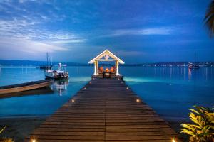 a dock with a gazebo on the water at night at Aore Island Resort in Luganville