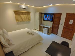 ein Hotelzimmer mit einem Bett und einem TV in der Unterkunft Hotel Ribeira dos Icós in Icó