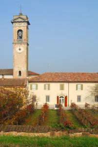 un grande edificio con una torre dell'orologio sullo sfondo di Ostello La Canonica a Motta Baluffi