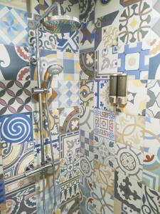 a bathroom with a shower with colorful tiles at Ático BELLAVISTA con visita a bodega y cata de vinos 4 habitaciones dobles 2 baños completos in Tudela