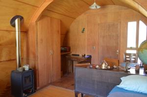 a room with a bed and a stove in a room at Refugios Canto del Agua in Villarrica