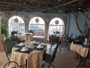 Cette chambre comprend des tables, des chaises et des fenêtres. dans l'établissement Marco Polo, à Tanger