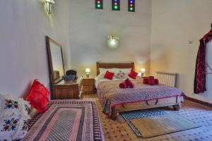 a bedroom with a bed and a mirror at Riad Zina Fes - Elegance in the Heart of Fes in Fès