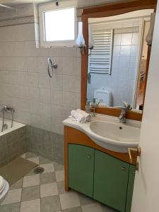 La salle de bains est pourvue d'un lavabo, d'une baignoire et d'un miroir. dans l'établissement Danai's Loft, à Héraklion