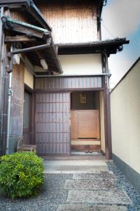 uma entrada para um edifício com uma porta de madeira em 阿美弥 一日一組様限定 em Quioto