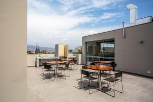 un patio con mesas y sillas en la parte superior de un edificio en GL Apts, en Lima