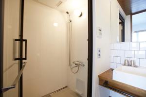uma casa de banho com um chuveiro e um lavatório. em No Service Hotel em Tóquio