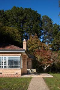 a house with two chairs sitting outside of it at Polperro Farmhouse in Red Hill