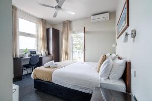 a bedroom with a bed and a desk and a window at Huskisson Hotel in Huskisson