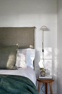 a bedroom with a bed with a lamp and a table at Polperro Farmhouse in Red Hill