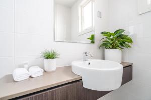 a bathroom with a sink, toilet and tub at The Huskisson in Huskisson