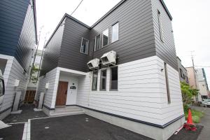 a house that is being painted black and white at UCHI Living Stay TOYOHIRA in Sapporo
