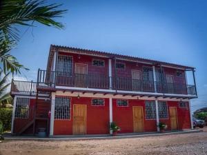 um edifício vermelho com uma varanda em cima em Sol de Playa em Playas