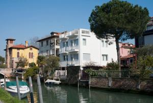 um edifício branco ao lado de um rio com barcos nele em Villa Venice Movie em Veneza-Lido