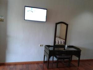 a mirror and a dresser and a chair in a room at Toraja Torsina Hotel in Rantepao
