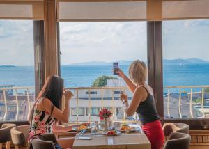 two women taking pictures of the ocean from a restaurant at Kaftan Hotel in Istanbul