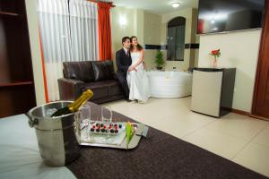 Una novia y un novio parados en una sala de estar en Hotel La Casona Del Olivo Arequipa, en Arequipa