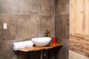 La salle de bains est pourvue d'un lavabo blanc sur un comptoir en bois. dans l'établissement Rincon del Montañes, à Antuco