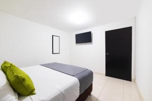 a bedroom with a bed and a tv on the wall at Ayenda 1045 Boutique Aeropuerto in Bogotá