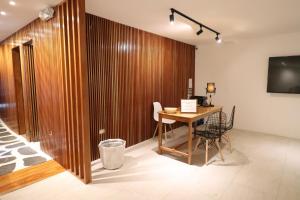 a room with a wooden wall with a table and a television at Cactus in Puerto Baquerizo Moreno