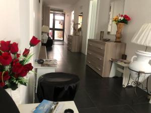 - un salon avec des roses rouges et une commode dans l'établissement Dolce Vita casa vacanze, à Carini